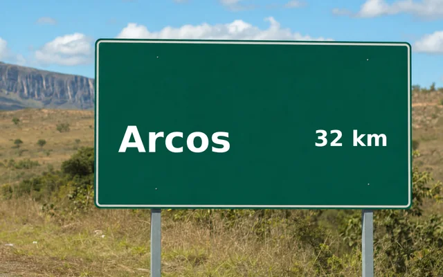 Placa de estrada indicando Arcos a 32 km