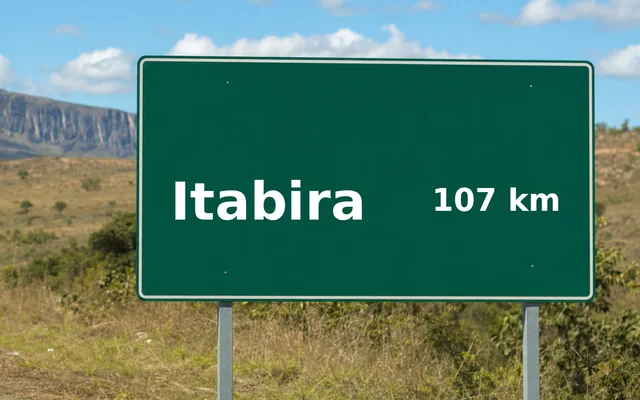 Placa de estrada indicando Itabira a 107 km