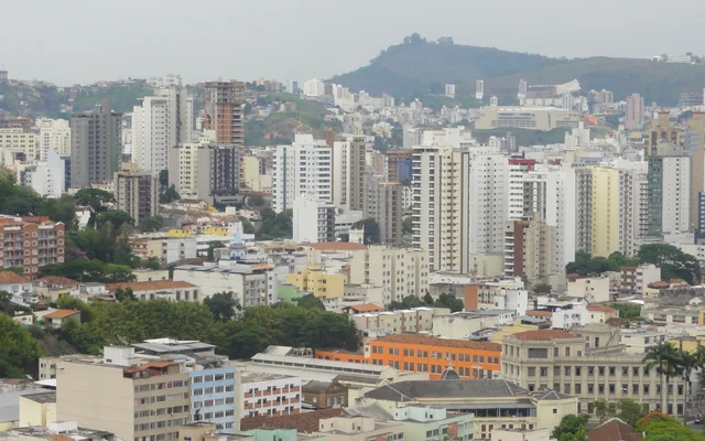 Vista da cidade com prédios e colinas em Juiz de Fora