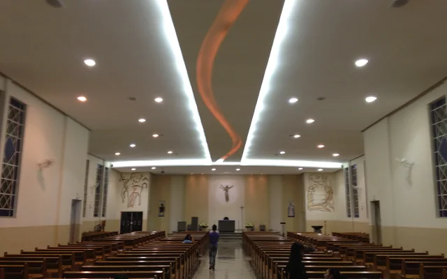 Interior de uma igreja com bancos em Varginha